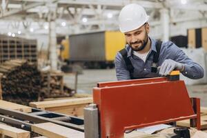 Carpenter working with woodworking machine in factory for modular building photo