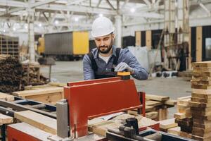 Carpenter operating woodworking machine in modular building factory photo
