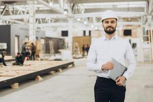 Engineer supervising prefabricated modular building construction in factory photo