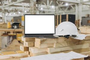 Laptop showing blank screen on lumber in modular building factory photo