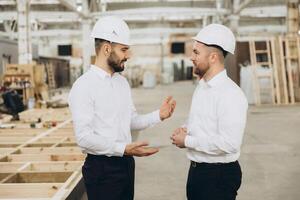 Engineers discussing building project in modular construction factory photo