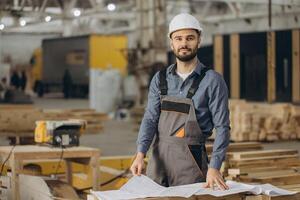Construction worker examining blueprints in modular building factory photo