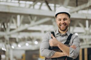 Smiling engineer gesturing thumbs up in modular building factory photo