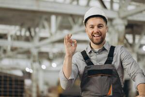 Smiling engineer gesturing ok sign in modular building factory photo