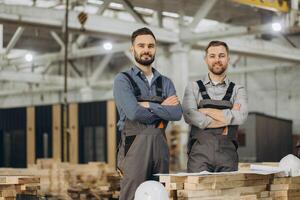 Engineers posing with arms crossed in modular building factory photo