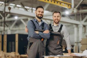 Engineers smiling and hugging in modular building factory photo