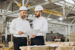 Engineers discussing plans in modular building factory photo