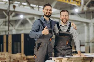 Engineers smiling and giving thumbs up in modular building factory photo