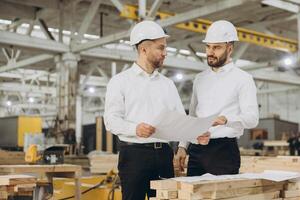 Engineers examining blueprint in modular building factory photo