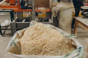 Sawdust filling big bag in carpentry workshop for modular building industry photo