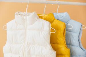 Sleeveless jackets hanging on hangers on rack photo