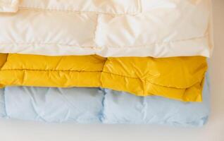 Stack of colorful winter jackets creating warm and cozy atmosphere photo