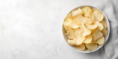 Top-down view of potato chips arranged in a shallow dish, placed next to a simple napkin, culinary photography photo