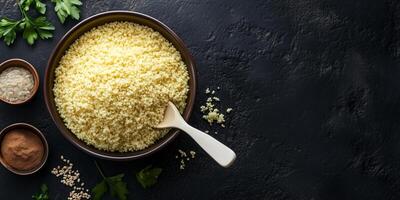Couscous in a deep ceramic bowl with visible ingredients and a spoon, food setting photo