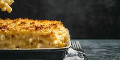 Serving of mac and cheese being plated from a large dish, meal photography photo