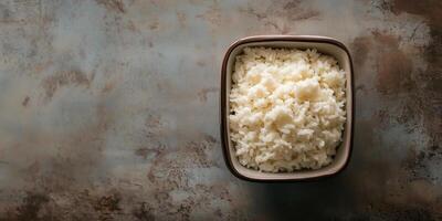 Sticky rice served in a compact square ceramic container on a table, food setting photo