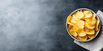 Top-down view of potato chips arranged in a shallow dish, placed next to a simple napkin, meal photography photo