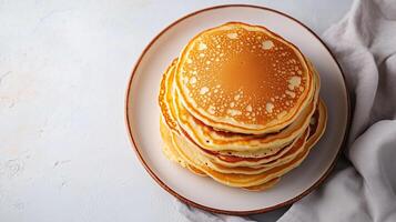 Plate of buttermilk pancakes arranged in a stack in the middle, culinary photography photo