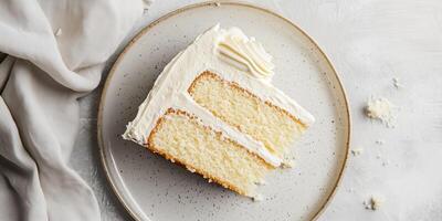 Slice of gluten-free cake on a plate showing layers of sponge and frosting, culinary photography photo