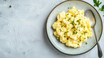 Scrambled eggs on a plate with a small serving of toast beside it, culinary photography photo