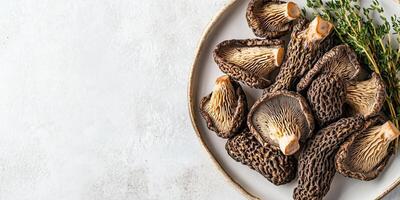 Sliced morels placed on a serving platter with sprigs of thyme, culinary photography photo