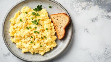 Scrambled eggs on a plate with a small serving of toast beside it, photorealistic food photo