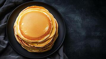 Plate of buttermilk pancakes arranged in a stack in the middle, food setting photo