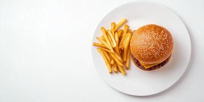Stack of fries next to a burger on a white plate, food setting photo