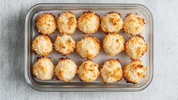 Container of vegan coconut macaroons, neatly stacked and ready for packaging, food photography photo