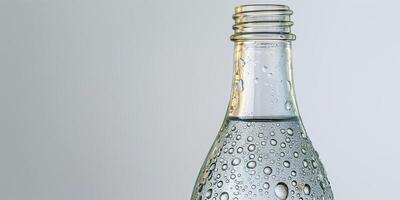 Glass bottle filled with clear sparkling water, condensation forming on the outside, on a white background, food photography photo