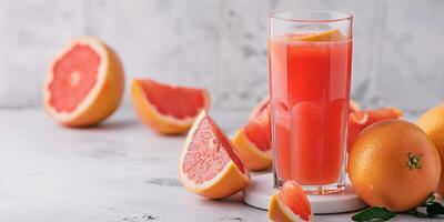 Glass filled with freshly squeezed grapefruit juice, set on a simple white tabletop, gastronomy photography photo