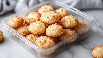 Container of vegan coconut macaroons, neatly stacked and ready for packaging, food setting photo