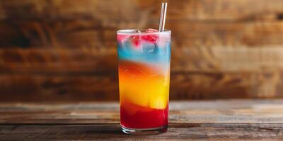 Tall glass of layered, colorful beverage with a straw, on a wooden surface, food setting photo