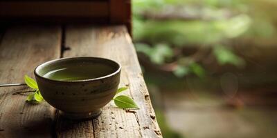 Traditional Japanese teacup with brewed kukicha tea, placed on a wooden surface, food setting photo