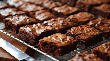 Rows of fudge brownies on a cooling rack, knife beside them, meal photography photo