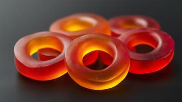 Chili-flavored gummy rings on a black background, uniformly shaped, food setting photo