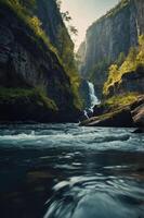 A serene waterfall cascading through a rocky gorge surrounded by lush greenery. photo