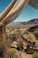 A desert scene featuring a snake among vegetation with mountains in the background. photo