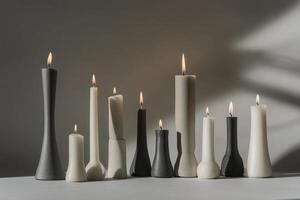 Row of Lit Candles in Various Shapes and Colors on a White Surface photo