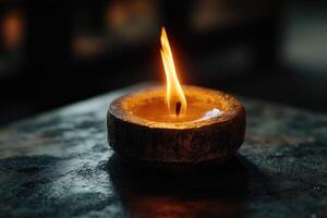 A Single Candle Flame Burning in a Wooden Bowl photo