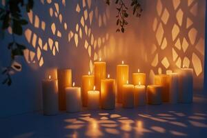 Lit Candles with Shadows Cast by Foliage on a White Wall photo