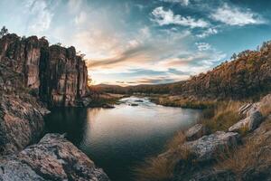 Tranquil River Winding Through A Rocky Landscape Under A Cloudy Sky photo
