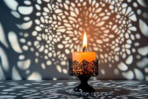 A Single Candle in a Decorative Holder with Intricate Shadow Patterns photo