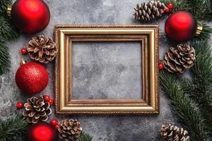 Christmas Ornament and Pine Cones Surrounding a Gold Frame photo