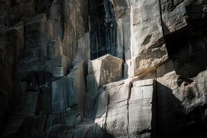 A Close-Up of a Rough, Gray Rock Face with Sunlit Patches photo