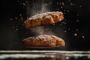 Two Brown Cookies Floating with Crumbs and Powdered Sugar in Air photo