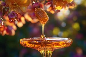 Golden Honey Dripping from a Dipper with a Flower Background photo