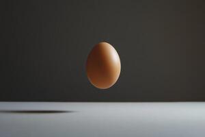 A Single Brown Egg Suspended in Mid-Air Over a White Surface photo