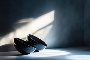 Two Black Bowls in a Corner Room with Sunlight Streaming In photo