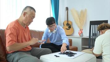 A father with grandchild plays games together in the living room to relax during the holidays photo